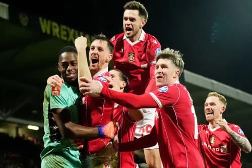 Wrexham goalkeeper Arthur Okonkwo celebrates with Dominic Hyam and team-mates. Pic: Alamy