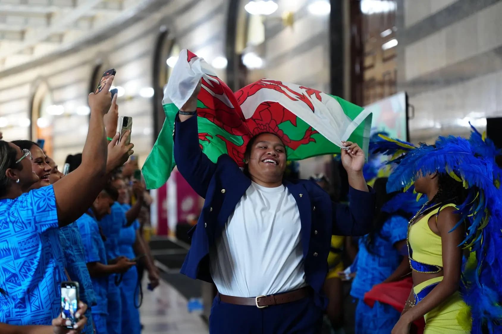 Wales' Sisilia Tuipulotu dances while holding a Welsh flag. Pic. Alamy