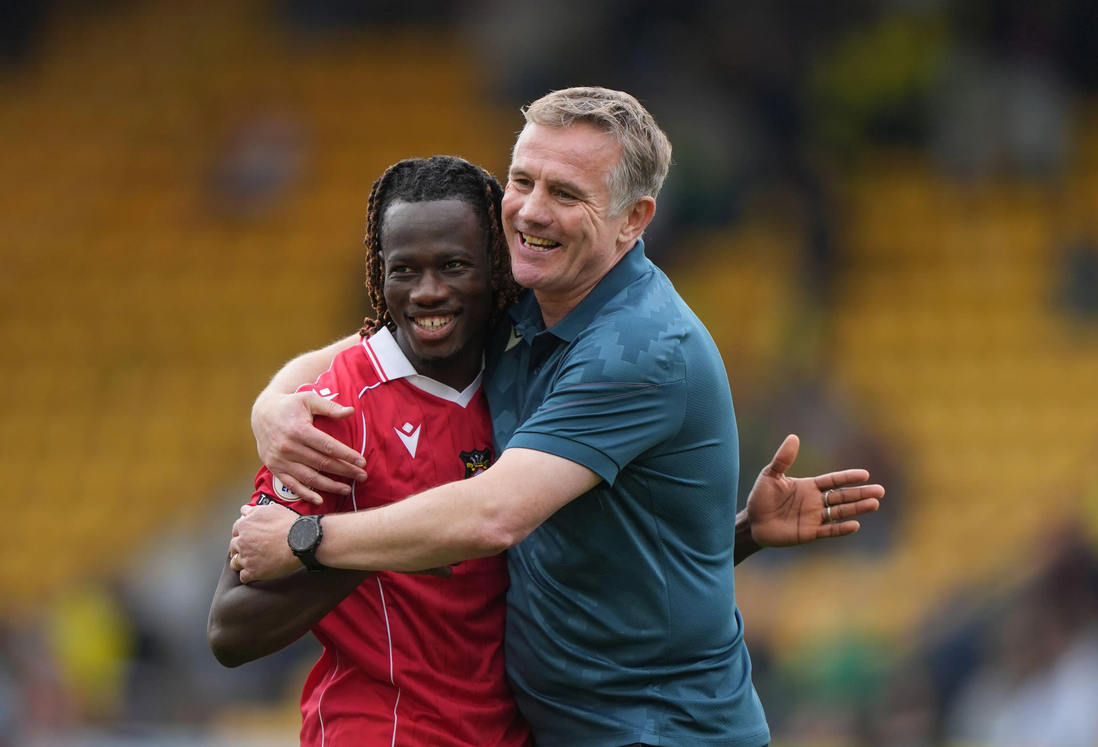 Wrexham manager Phil Parkinson has a hug for Issa Kabore. Pic. Alamy