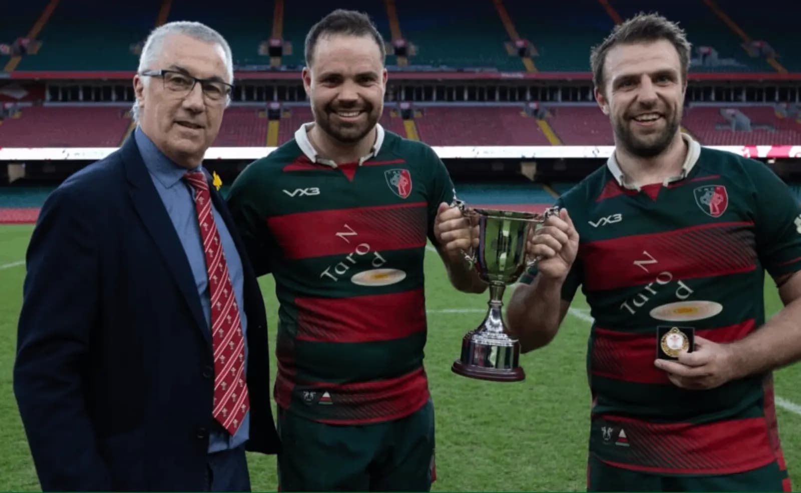 Clwb Rygbi Cymry Caerdydd co captains, Cai Hayes and Harry Moyle receive the Division 2 Cup from Geraint John, WRU Community Director. Pic: WRU