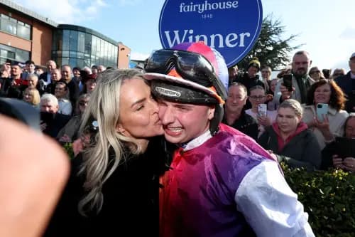 Jockey Sean Bowen is kissed by trainer Rebecca Curtis as they celebrate after their horse Haiti Couleurs won the Irish Grand National.