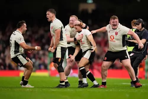 Wales players celebrate with matchwinner Jarrod Evans. Pic: Alamy