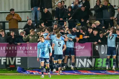 Ben Lloyd of Newport County celebrates scoring his side's second goal with teammates and fans. Pic: Alamy.